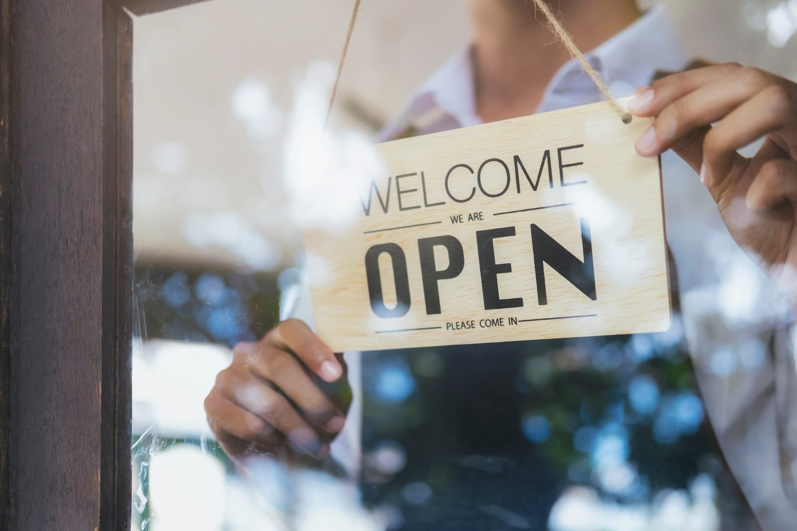 place de uma loja escrito welcome we are open
